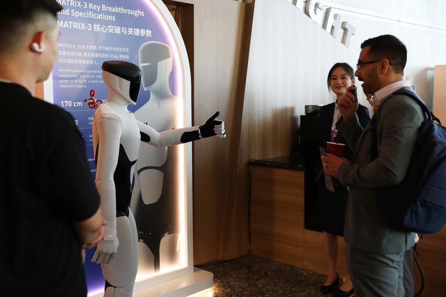 Ein Roboter zeigt einem Teilnehmer des Summer Davos in Dalian den Daumen nach oben